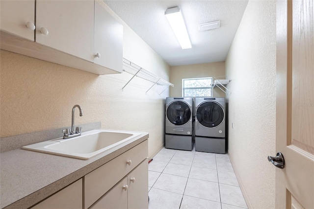 25538 Rampart Blvd, Punta Gorda, FL 33983 - laundry area featuring separate washer and dryer, cabinet space, a textured wall, and light tile patterned floors