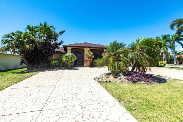 25538 Rampart Blvd, Punta Gorda, FL 33983 - view of front of house with concrete driveway, a front lawn, and stucco siding