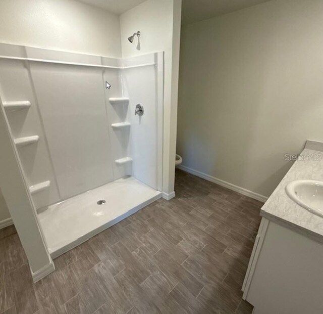 5 Princess Luise Ln, Palm Coast, FL 32164 - bathroom featuring a shower stall, wood finished floors, vanity, and baseboards