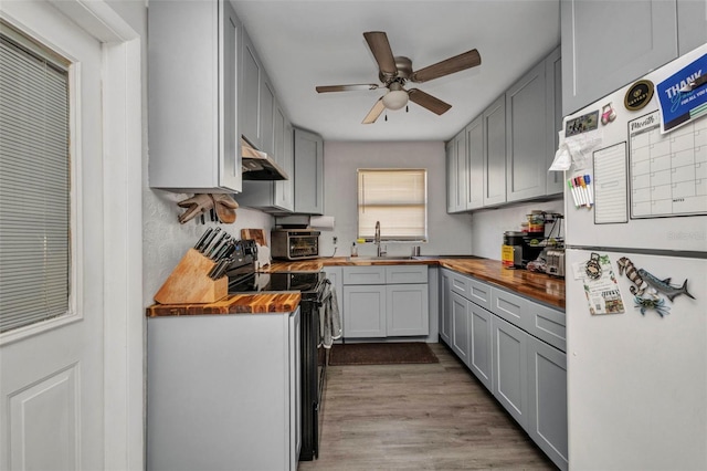2465 Deedra St, Port Charlotte, FL 33952 - kitchen with wooden counters, freestanding refrigerator, black / electric stove, a sink, and gray cabinetry