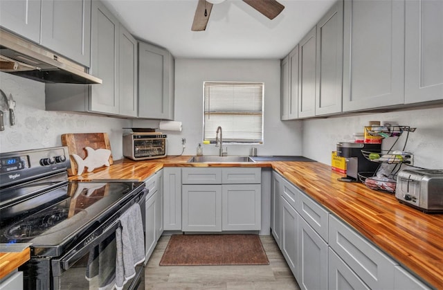 2465 Deedra St, Port Charlotte, FL 33952 - kitchen with wood counters, black electric range, a sink, under cabinet range hood, and gray cabinets