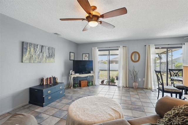 4358 Pates St, Port Charlotte, FL 33948 - living area with ceiling fan, plenty of natural light, a textured ceiling, baseboards, and light tile patterned floors