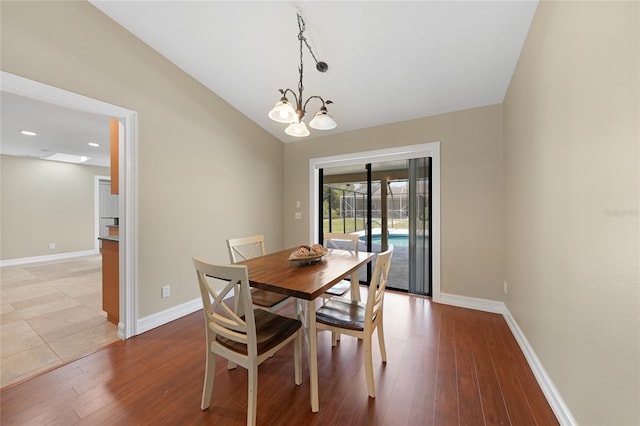 1039 Marlene St, Port Charlotte, FL 33952 - dining area featuring baseboards, light wood-style floors, a chandelier, and vaulted ceiling
