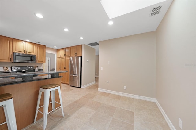 1039 Marlene St, Port Charlotte, FL 33952 - kitchen with appliances with stainless steel finishes, a kitchen breakfast bar, dark stone counters, recessed lighting, and baseboards