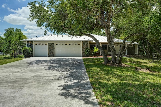 17340 Oak Creek Rd, Alva, FL 33920 - ranch-style home featuring stone siding, a garage, a front lawn, and concrete driveway