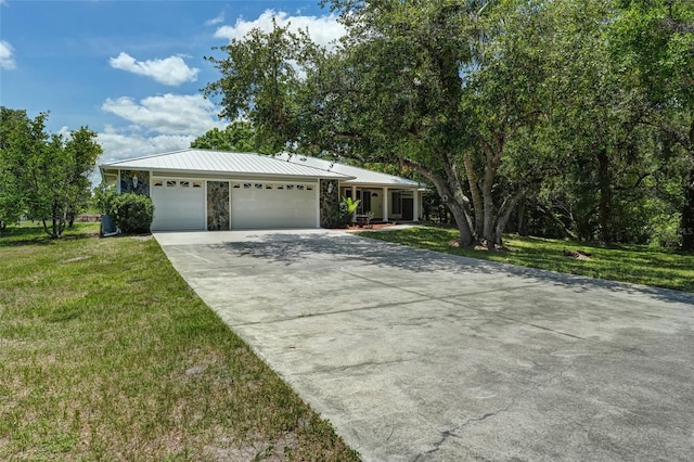 17340 Oak Creek Rd, Alva, FL 33920 - view of front of house with concrete driveway, a garage, a front lawn, and stone siding