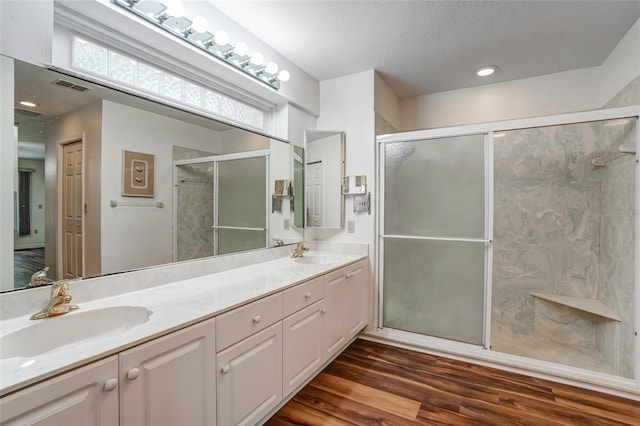 17340 Oak Creek Rd, Alva, FL 33920 - bathroom featuring double vanity, a shower stall, wood finished floors, and a textured ceiling