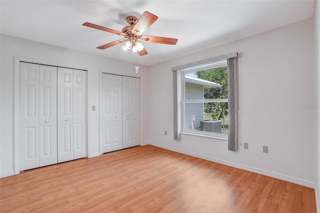 17340 Oak Creek Rd, Alva, FL 33920 - unfurnished bedroom with multiple closets, light wood-style floors, baseboards, and ceiling fan
