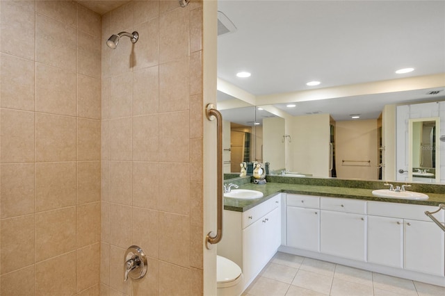 601 Shreve St Unit 21C, Punta Gorda, FL 33950 - bathroom with double vanity, tile patterned flooring, recessed lighting, tiled shower, and toilet