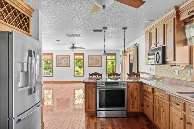 4317 Mccullough St, Port Charlotte, FL 33948 - kitchen featuring appliances with stainless steel finishes, ceiling fan, a peninsula, dark wood finished floors, and pendant lighting