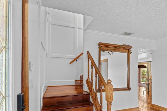 4317 Mccullough St, Port Charlotte, FL 33948 - stairs with a textured ceiling, wood finished floors, and ornamental molding