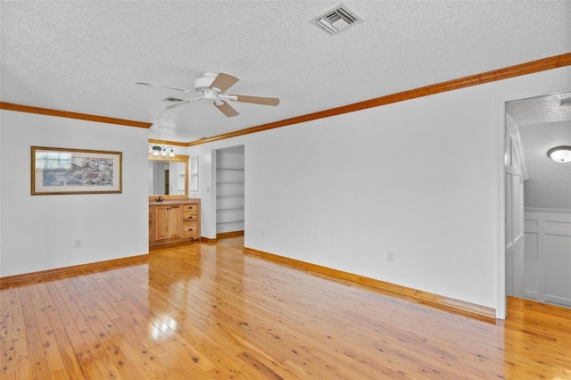 4317 Mccullough St, Port Charlotte, FL 33948 - unfurnished living room featuring a textured ceiling, a ceiling fan, light wood-type flooring, crown molding, and built in features