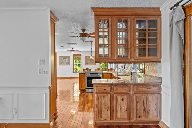 4317 Mccullough St, Port Charlotte, FL 33948 - bar area featuring stainless steel electric stove, a textured ceiling, light wood-style floors, decorative backsplash, and a ceiling fan