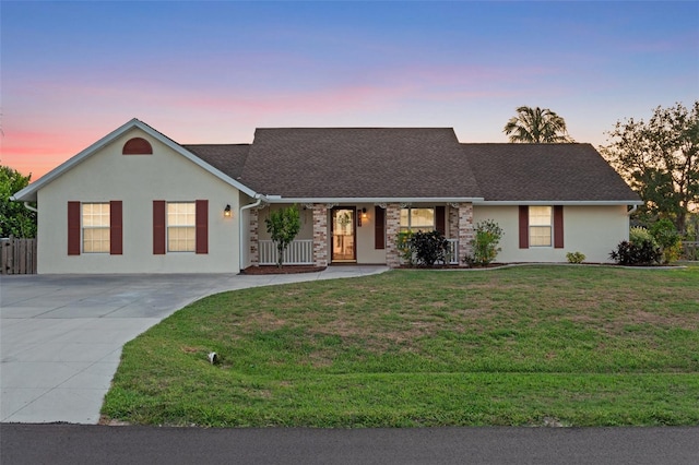 4317 Mccullough St, Port Charlotte, FL 33948 - view of front facade featuring a yard, concrete driveway, stucco siding, covered porch, and roof with shingles