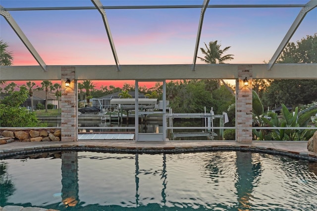 4317 Mccullough St, Port Charlotte, FL 33948 - pool at dusk with boat lift, an outdoor pool, a boat dock, and glass enclosure