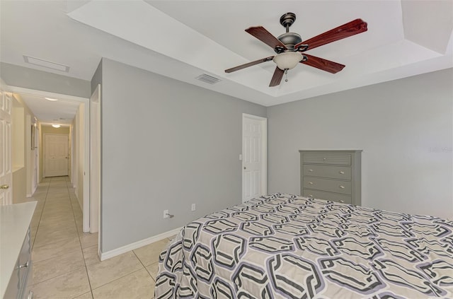 13210 SW Pembroke Cir N, Lake Suzy, FL 34269 - bedroom with light tile patterned floors, a tray ceiling, baseboards, and a ceiling fan