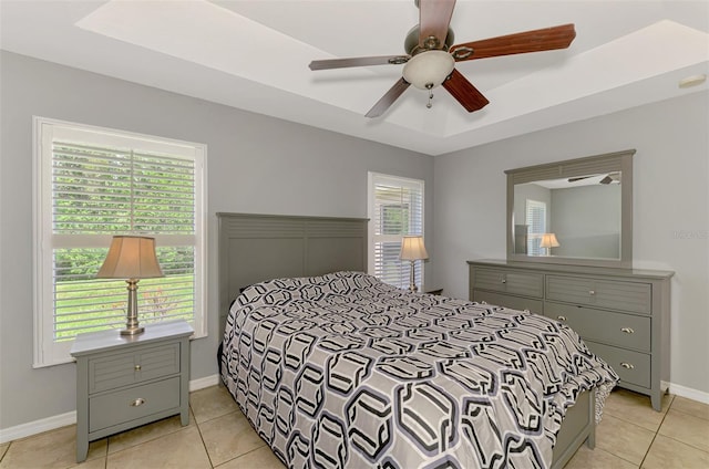 13210 SW Pembroke Cir N, Lake Suzy, FL 34269 - bedroom with light tile patterned flooring, baseboards, a tray ceiling, and ceiling fan