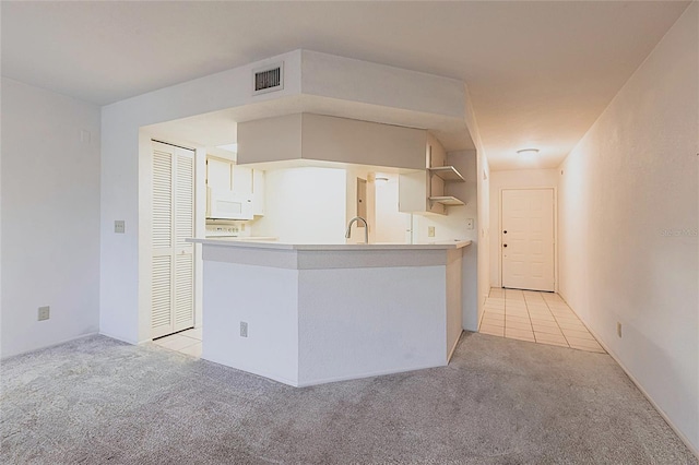 3256 White Ibis Ct Unit 24A, Punta Gorda, FL 33950 - kitchen with light carpet, a sink, a peninsula, and open shelves