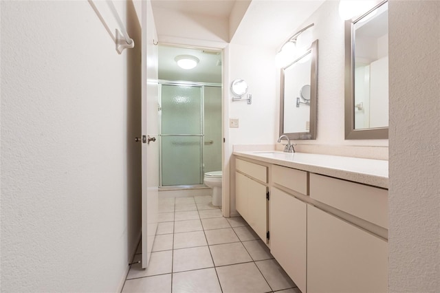 3256 White Ibis Ct Unit 24A, Punta Gorda, FL 33950 - bathroom featuring toilet, vanity, a stall shower, tile patterned flooring, and a textured wall