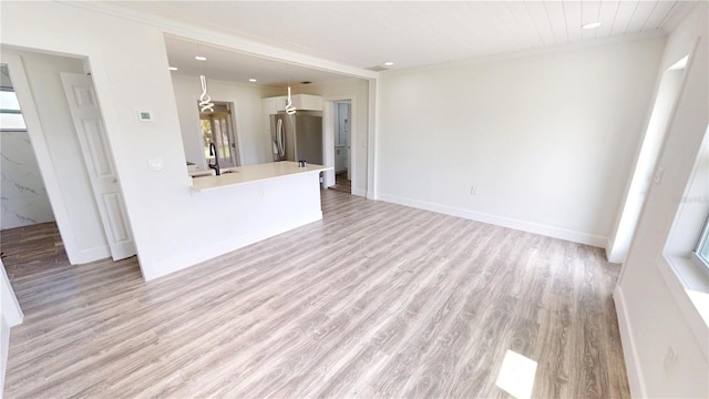 2805 Gussie St, Punta Gorda, FL 33950 - unfurnished living room with light wood-type flooring, ornamental molding, a sink, baseboards, and recessed lighting