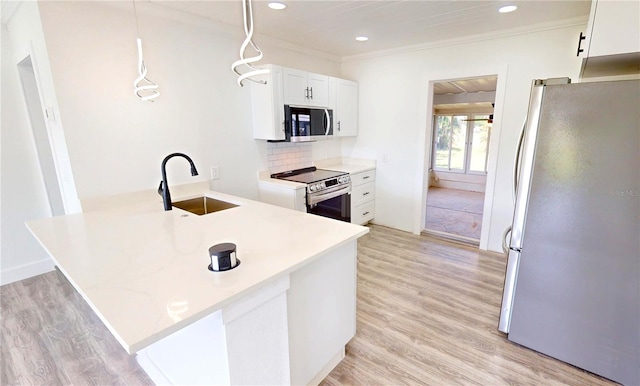2805 Gussie St, Punta Gorda, FL 33950 - kitchen with appliances with stainless steel finishes, a sink, ornamental molding, a peninsula, and light wood-style flooring
