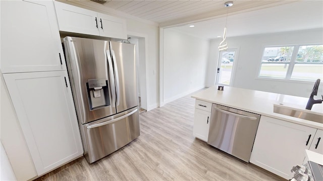 2805 Gussie St, Punta Gorda, FL 33950 - kitchen featuring appliances with stainless steel finishes, a sink, light wood finished floors, white cabinetry, and pendant lighting