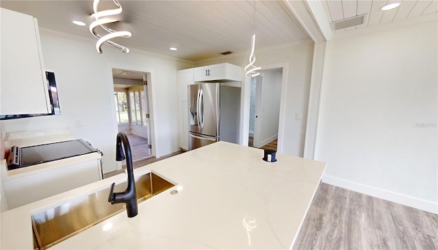 2805 Gussie St, Punta Gorda, FL 33950 - kitchen featuring stainless steel fridge with ice dispenser, wood finished floors, ornamental molding, white cabinetry, and light stone counters