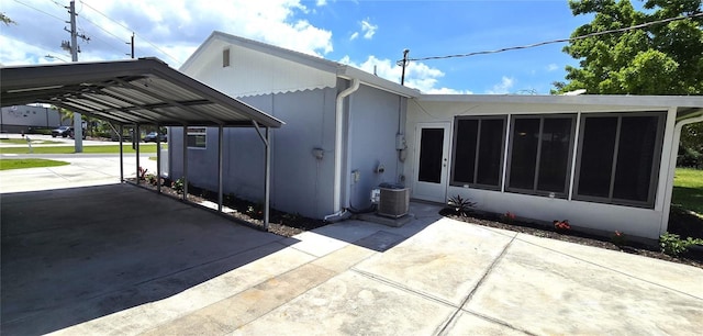 2805 Gussie St, Punta Gorda, FL 33950 - rear view of house with a sunroom, concrete driveway, central air condition unit, and a detached carport