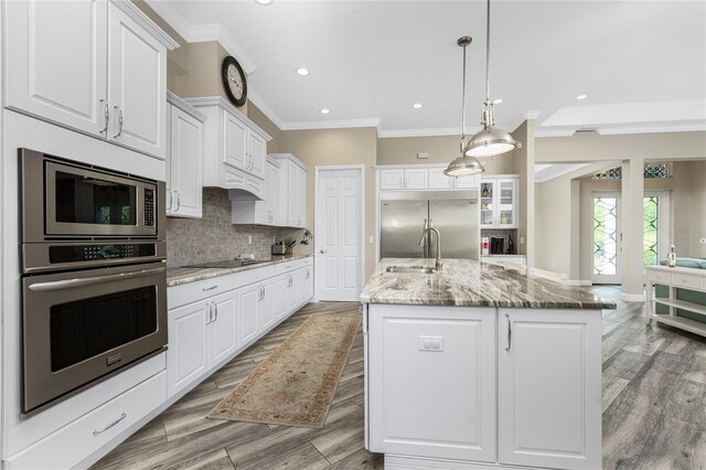 1025 Cheshire St, Port Charlotte, FL 33953 - kitchen with built in appliances, a sink, crown molding, white cabinets, and decorative backsplash