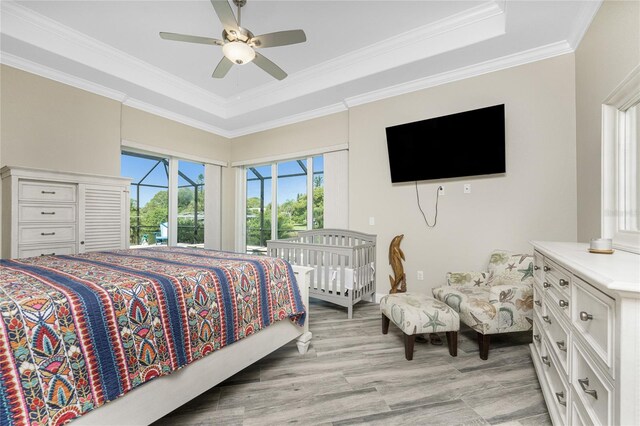 1025 Cheshire St, Port Charlotte, FL 33953 - bedroom featuring a tray ceiling, crown molding, access to exterior, light wood finished floors, and a ceiling fan