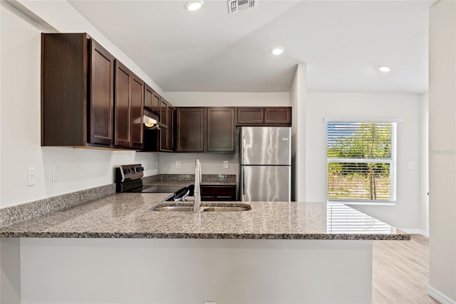 27237 Partin Dr, Punta Gorda, FL 33983 - kitchen featuring stainless steel appliances, a sink, a peninsula, dark brown cabinetry, and light stone counters