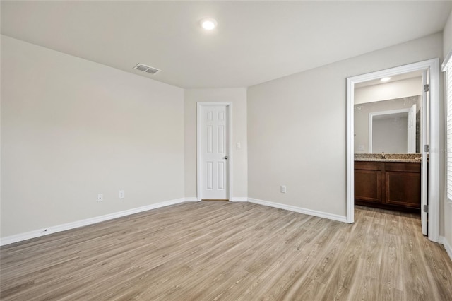27237 Partin Dr, Punta Gorda, FL 33983 - unfurnished bedroom with light wood-type flooring, baseboards, a sink, recessed lighting, and connected bathroom