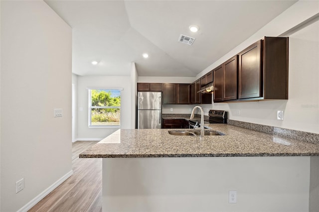 27237 Partin Dr, Punta Gorda, FL 33983 - kitchen featuring appliances with stainless steel finishes, a sink, dark brown cabinetry, a peninsula, and stone counters