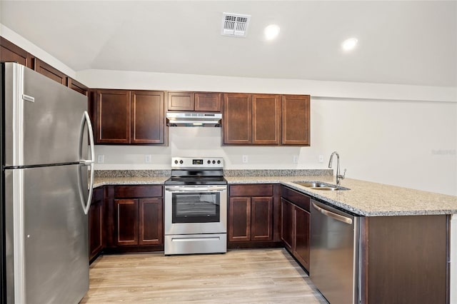 27237 Partin Dr, Punta Gorda, FL 33983 - kitchen with stainless steel appliances, a sink, under cabinet range hood, a peninsula, and light stone countertops