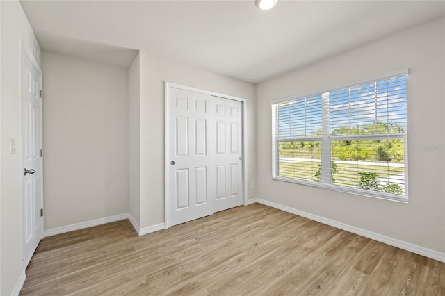 27237 Partin Dr, Punta Gorda, FL 33983 - unfurnished bedroom with baseboards, light wood finished floors, and multiple windows