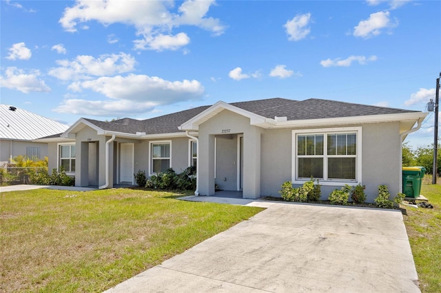 27237 Partin Dr, Punta Gorda, FL 33983 - ranch-style house with stucco siding, a front lawn, and roof with shingles