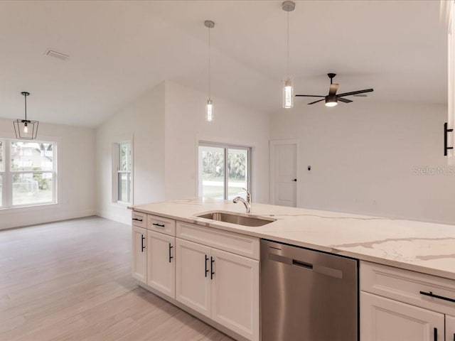 17130 Elder St, Port Charlotte, FL 33954 - kitchen with stainless steel dishwasher, a sink, white cabinetry, light wood-style floors, and vaulted ceiling