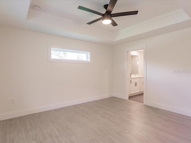 17130 Elder St, Port Charlotte, FL 33954 - empty room with ornamental molding, a tray ceiling, a ceiling fan, and light wood finished floors