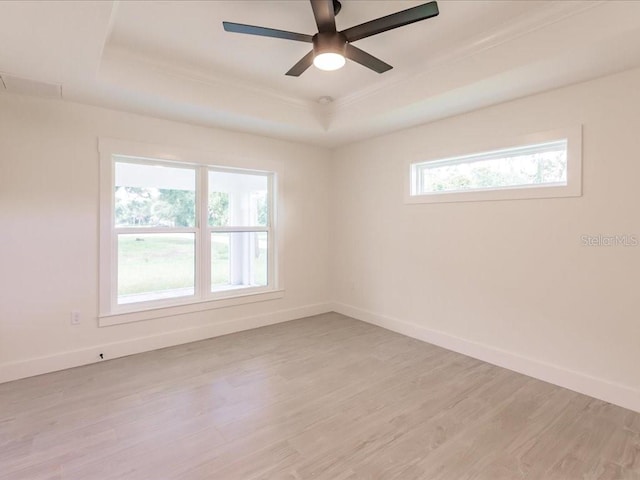 17130 Elder St, Port Charlotte, FL 33954 - empty room featuring a tray ceiling, crown molding, light wood-style floors, baseboards, and ceiling fan