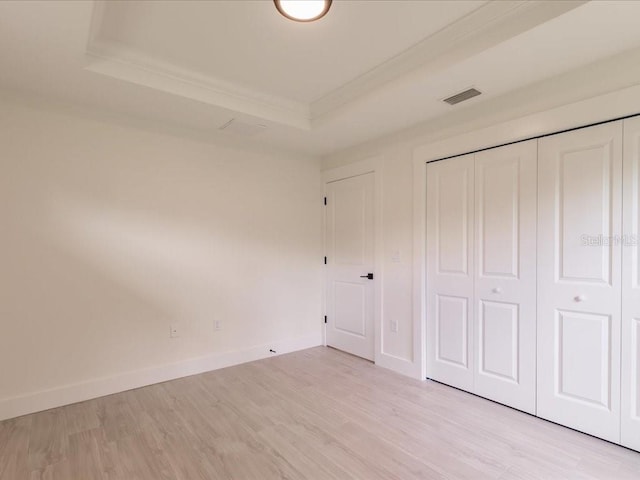 17130 Elder St, Port Charlotte, FL 33954 - unfurnished bedroom with a raised ceiling, ornamental molding, light wood finished floors, a closet, and baseboards