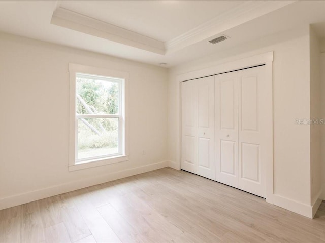 17130 Elder St, Port Charlotte, FL 33954 - unfurnished bedroom with baseboards, crown molding, light wood-style floors, and a tray ceiling