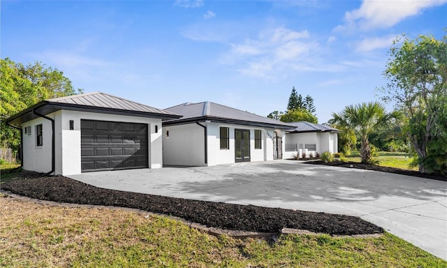 19723 Midway Blvd, Port Charlotte, FL 33948 - view of front of property featuring driveway, an attached garage, a standing seam roof, metal roof, and stucco siding