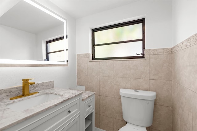 19723 Midway Blvd, Port Charlotte, FL 33948 - bathroom with tile walls, toilet, vanity, and a wainscoted wall