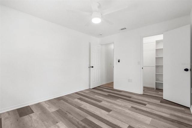 19723 Midway Blvd, Port Charlotte, FL 33948 - unfurnished bedroom with wood finished floors, a walk in closet, a closet, and ceiling fan