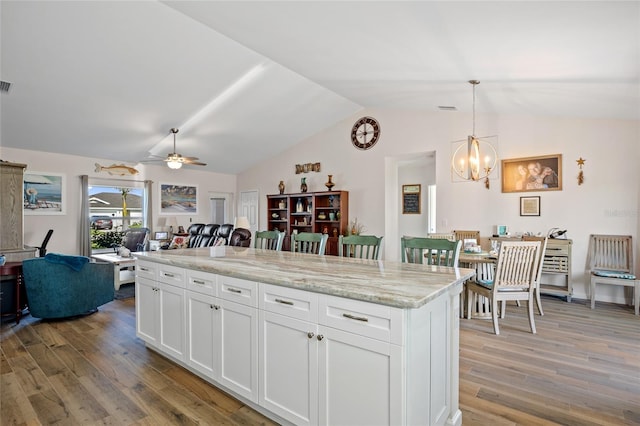 16094 Ortega Dr, Punta Gorda, FL 33955 - kitchen featuring vaulted ceiling, open floor plan, a chandelier, light wood-style flooring, and white cabinets