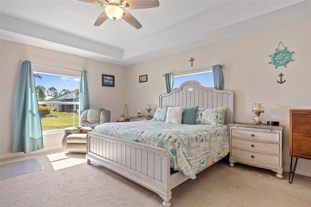 16094 Ortega Dr, Punta Gorda, FL 33955 - bedroom with light colored carpet, ceiling fan, and a tray ceiling