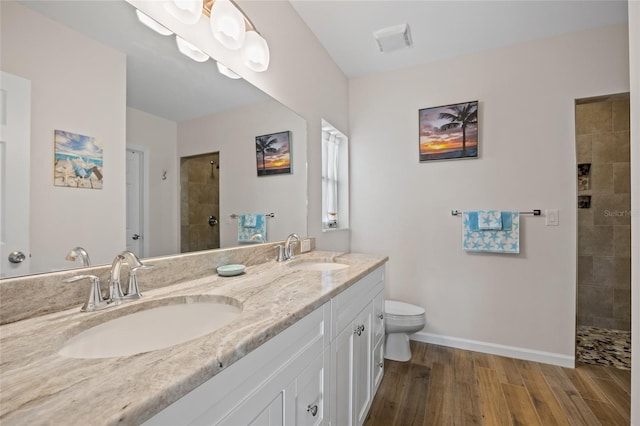 16094 Ortega Dr, Punta Gorda, FL 33955 - full bath with double vanity, a tile shower, wood finished floors, toilet, and baseboards