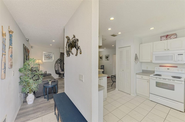 4044 S Salford Blvd, North Port, FL 34287 - kitchen with white appliances, a textured ceiling, white cabinets, recessed lighting, and light countertops