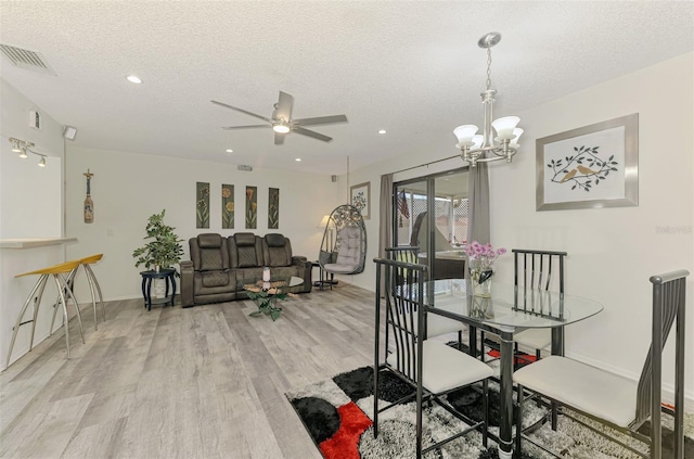 4044 S Salford Blvd, North Port, FL 34287 - dining room with light wood-style flooring, a textured ceiling, a ceiling fan, a chandelier, and recessed lighting
