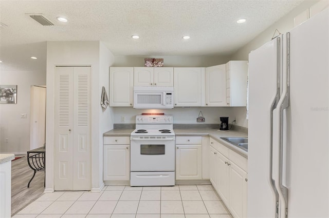 4044 S Salford Blvd, North Port, FL 34287 - kitchen with white appliances, white cabinets, light countertops, a textured ceiling, and recessed lighting